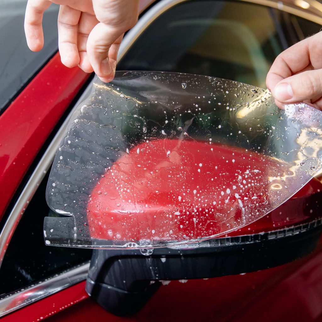 Master man installs vinyl film in risk zone of windshield to protect car body paint.